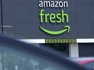 caption: Amazon laid off workers at its brick-and-mortar grocery stores last week — the latest sign of the e-commerce giant's struggles to stand out in the competitive grocery landscape.
