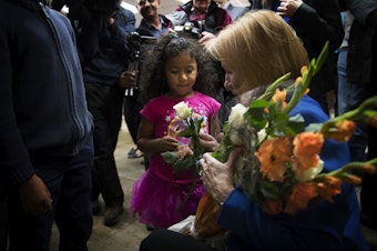 caption:  Seattle mayor Jenny Durkan gives a rose to 4-year-old Araceli Cotto, after taking the oath of office on Tuesday, November 28, 2017, at the Ethiopian Community Center in Seattle. 