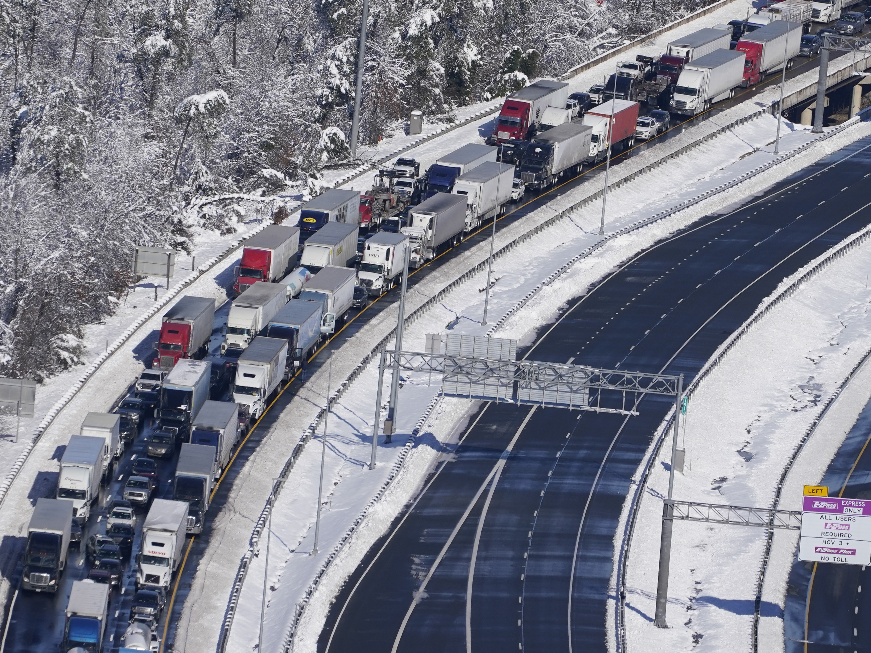 caption: Cars and trucks are stranded on sections of Interstate 95 Tuesday Jan. 4, 2022, near Quantico, Va. Close to 48 miles of the Interstate was closed due to ice and snow.