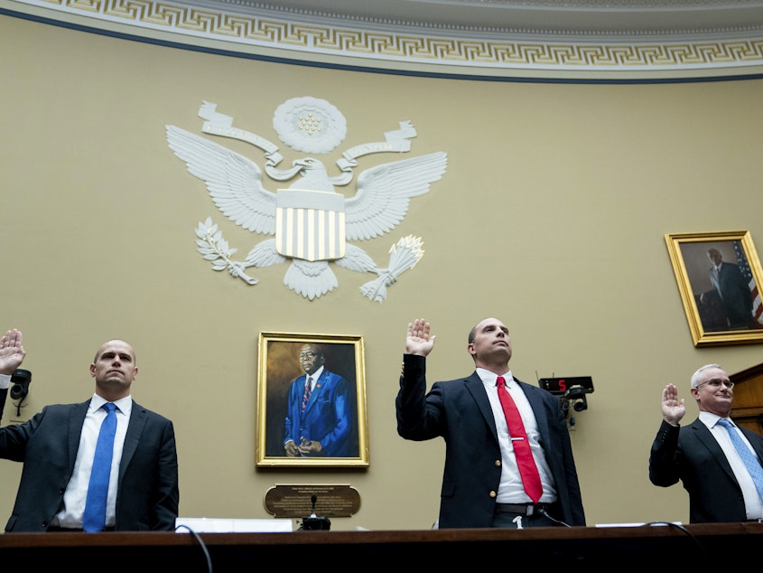 caption: Ryan Graves, executive director of Americans for Safe Aerospace (left), retired Air Force Maj. David Grusch and retired Navy Cmdr. David Fravor are sworn in during a House Oversight and Accountability subcommittee hearing on UFOs on Wednesday.