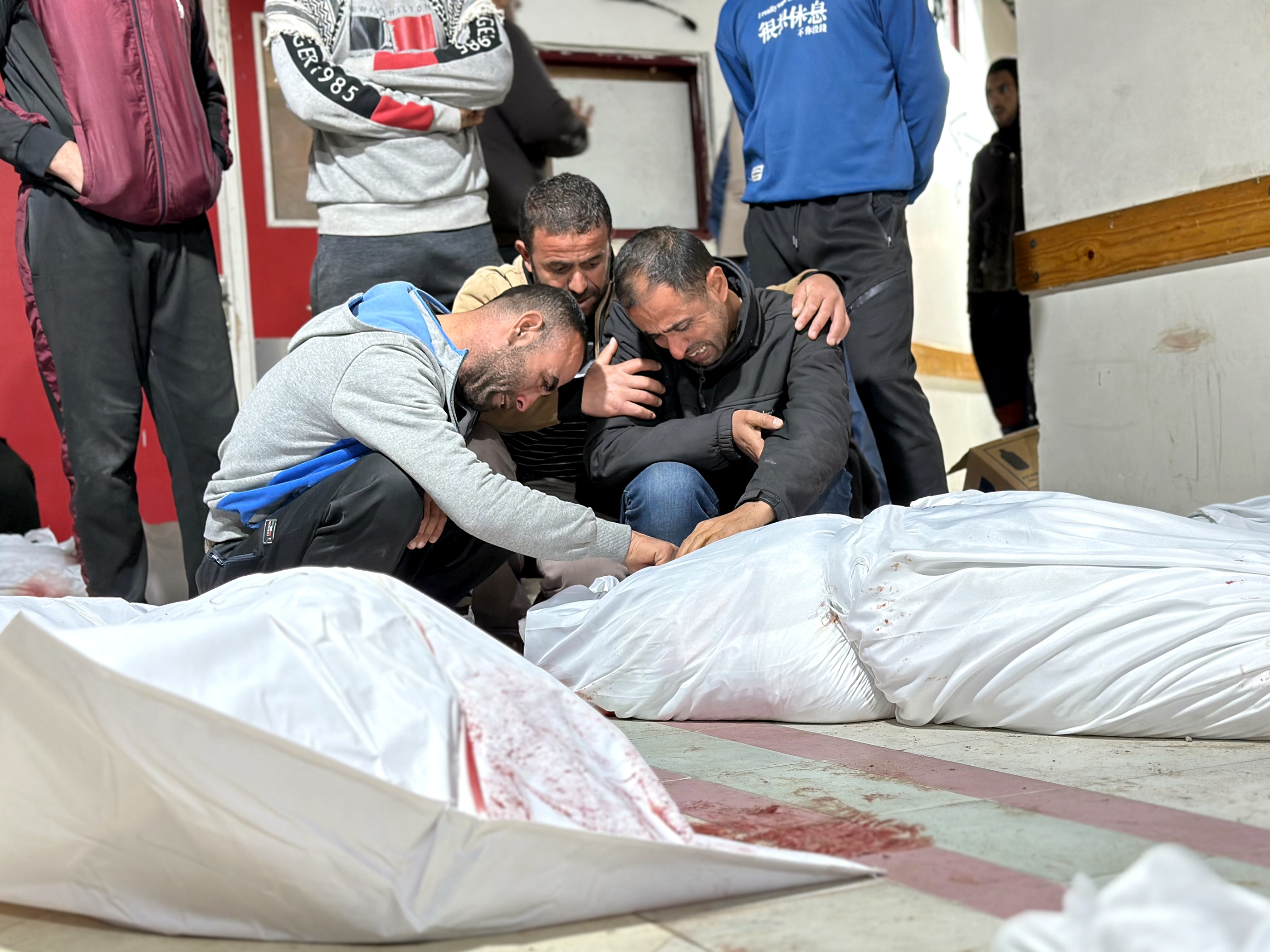 caption: Fayez Abu Halima, 39, (right) and his brothers cry over the body of their mother killed in Israeli airstrikes on homes in northern Gaza's Beit Lahia. He tells NPR from the hospital morgue: "We did not expect the war to restart with such ferocity… We are living in hell." At least 25 members of the family were killed in the pre-dawn airstrikes Mar. 20, 2025.