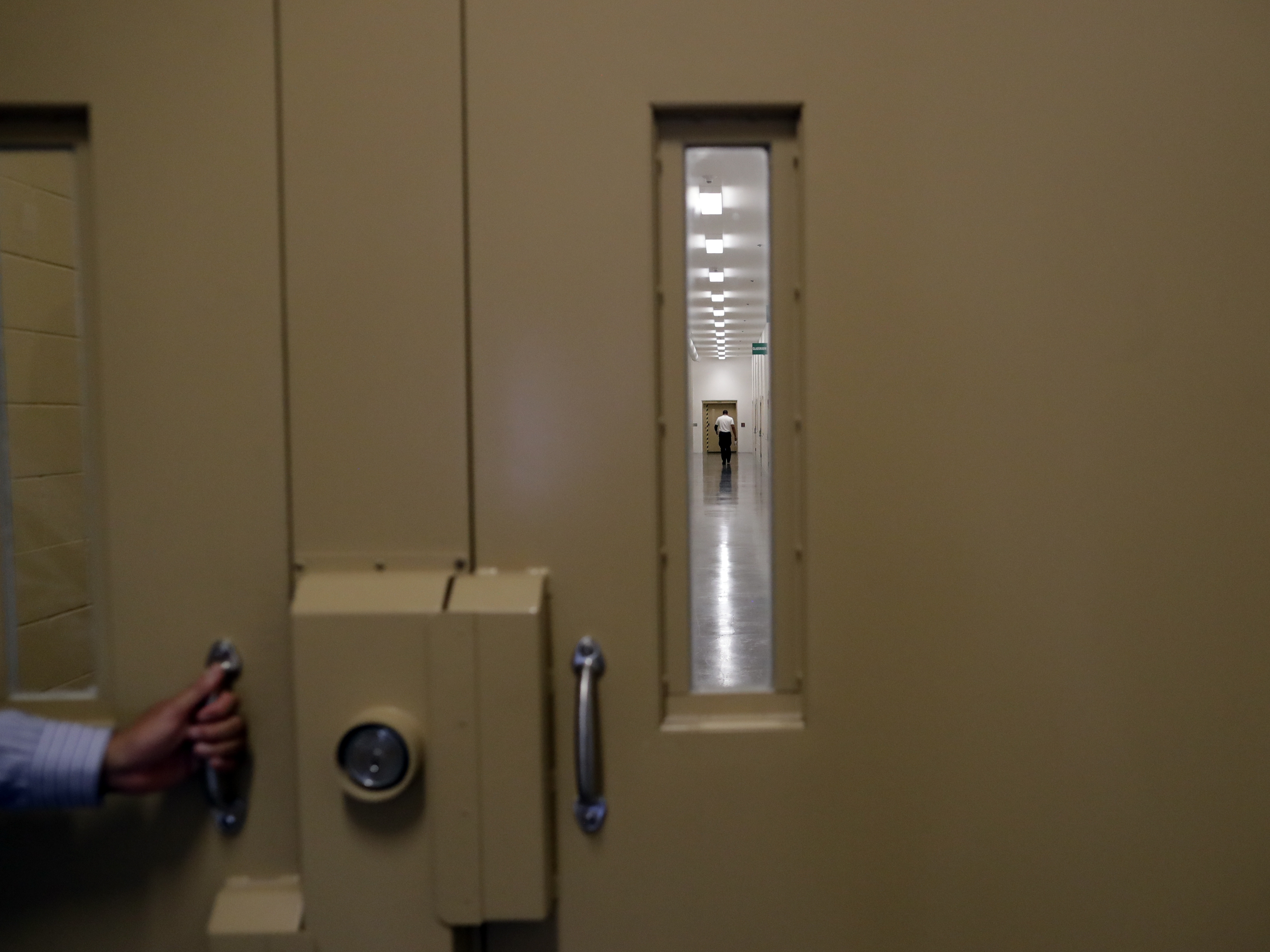 caption: A man walks in a hallway at the Otay Mesa Detention Center Wednesday, Aug. 23, 2017, in San Diego.
