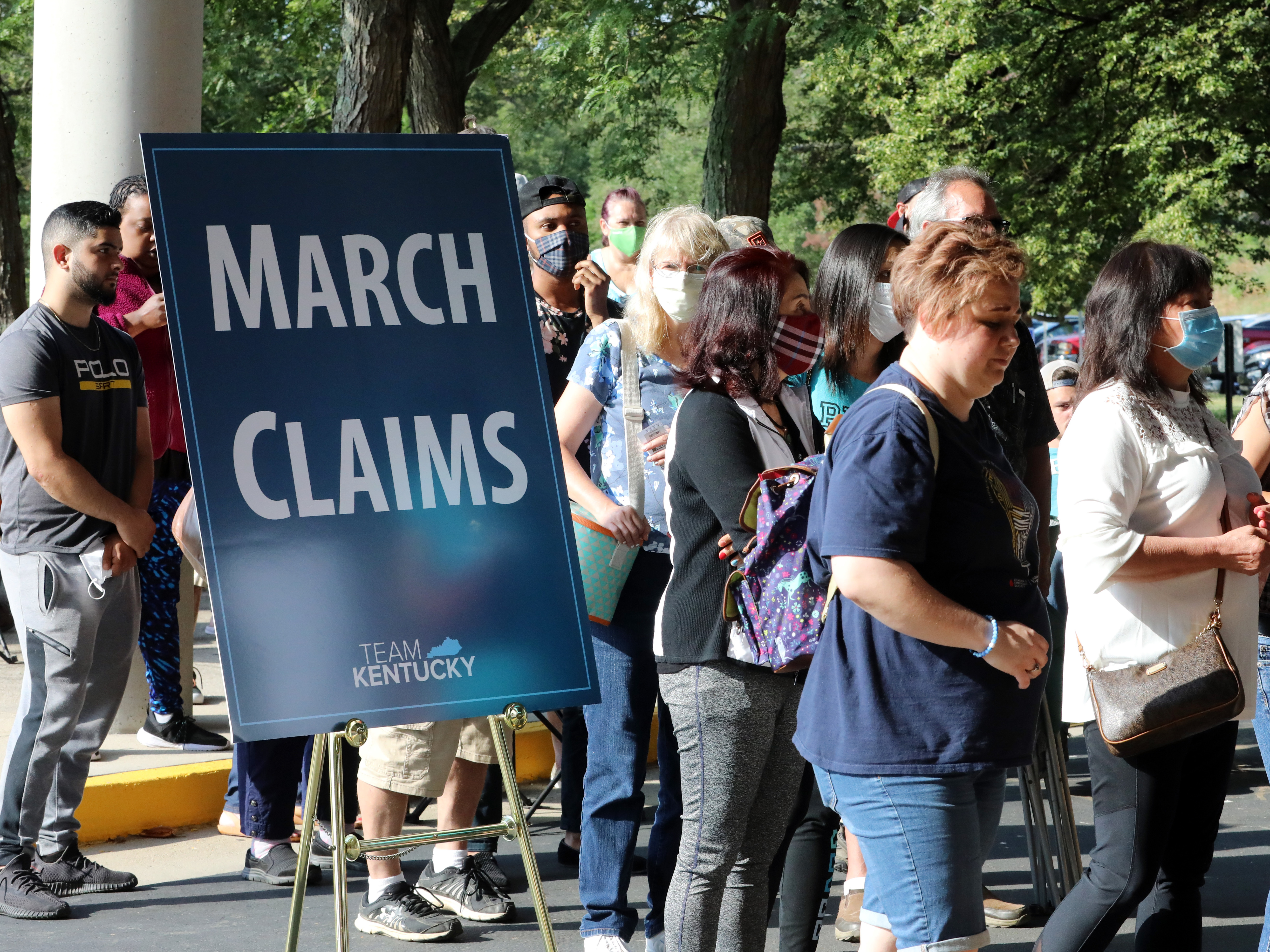 caption: Hundreds of unemployed Kentucky residents wait in long lines outside the Kentucky Career Center in Frankfort for help with their unemployment claims on June 19. New research shows savings built up by the jobless are starting to run out.