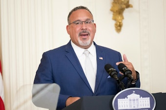 caption: "Our nation's educational institutions should be places where we not only accept differences, but celebrate them," U.S. Education Secretary Miguel Cardona, seen in the East Room of the White House in August 2023, said of the new Title IX regulation.