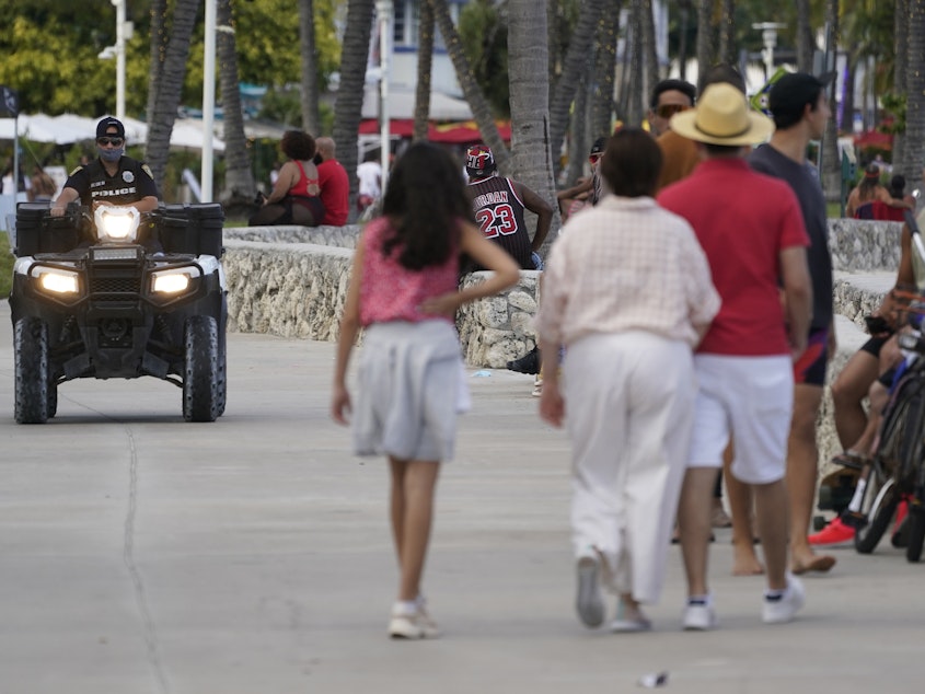 caption: A police officer on an ATV patrols in Miami Beach, Fla.'s famed South Beach in March 2021. City of Miami Beach officials declared a state of emergency on Monday, and an upcoming curfew, bidding to curb violent incidents at spring break that saw five people wounded in two separate shootings.