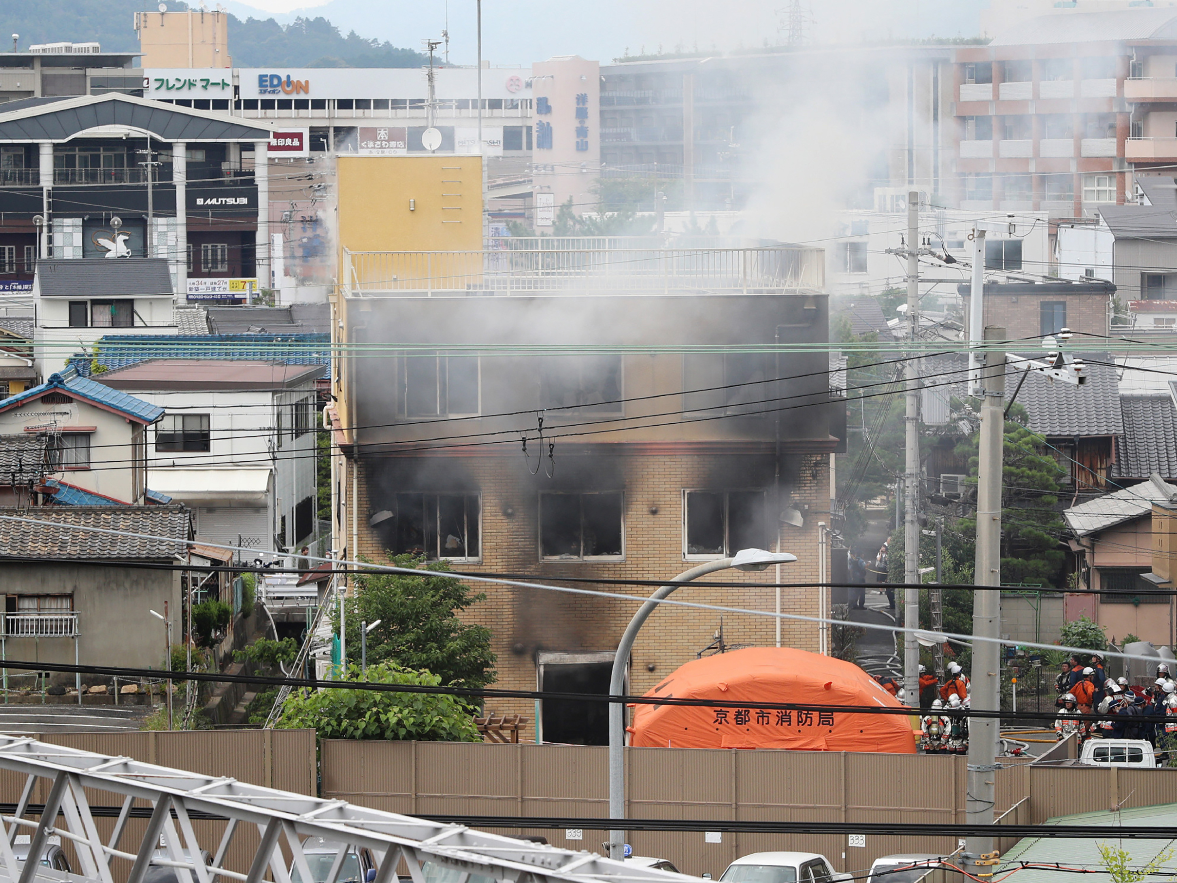 caption: Smoke rises from an animation company building after a fire in Kyoto, Japan, on Thursday.