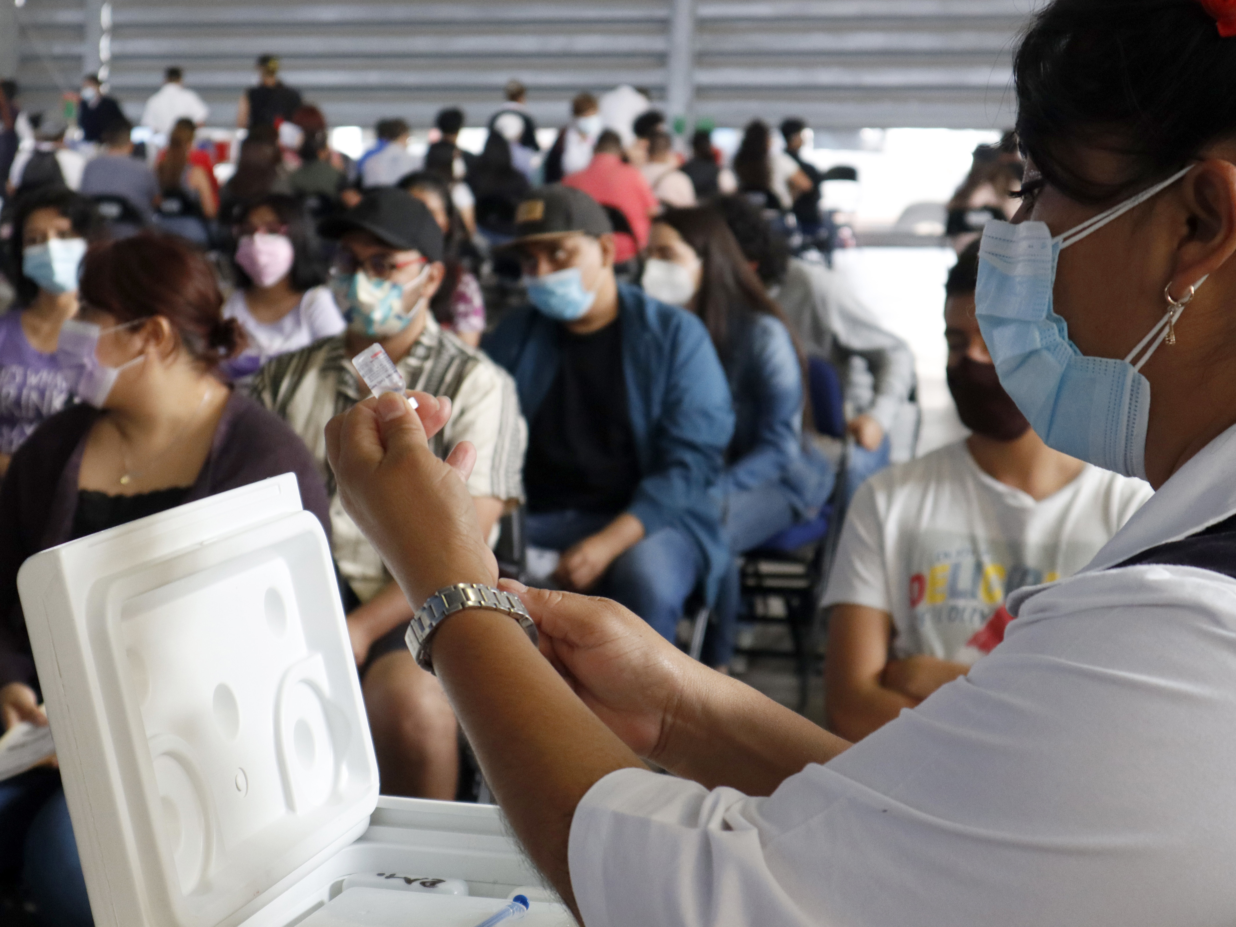 caption: A health worker in Mexico City prepares a Sputnik V dose during a mass vaccination effort against COVID-19. A new study in Mexico shows that non-mRNA vaccines like the Russian version can be as effective as mRNA vaccines like Pfizer if the patient has previously been infected with SARS-CoV-2.