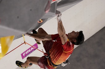 caption: Spain's Alberto Ginés López climbs during the Sport Climbing men's combined final of the Tokyo Olympic Games.
