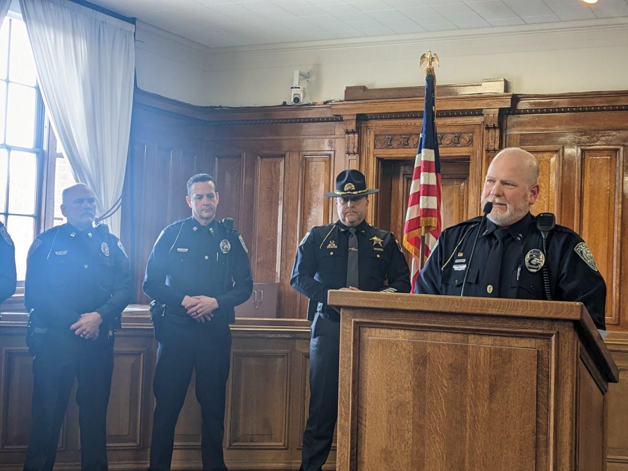 caption: Moscow Police Chief James Fry stands and takes questions at a press conference Friday afternoon in Moscow, Idaho. Police say they’ve apprehended a suspect in the quadruple homicide in the rural college town.  