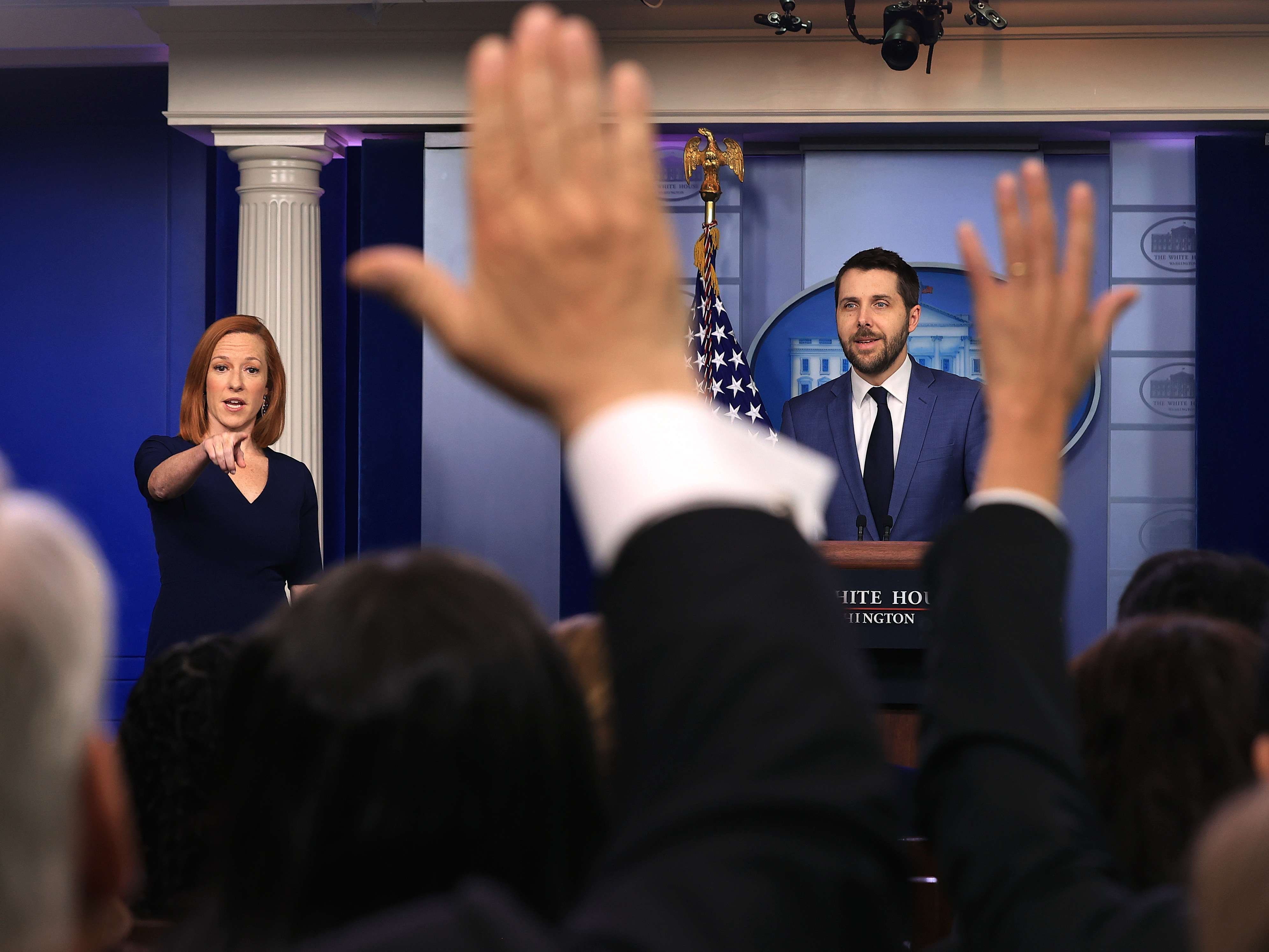 caption: White House press secretary Jen Psaki and Brian Deese, director of the National Economic Council, take questions from reporters on Friday.