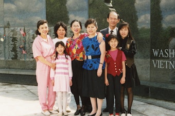 caption: Thanh Tan (bottom row, right), her family and friends at the Washington State Vietnam Veterans Memorial in 1990. 