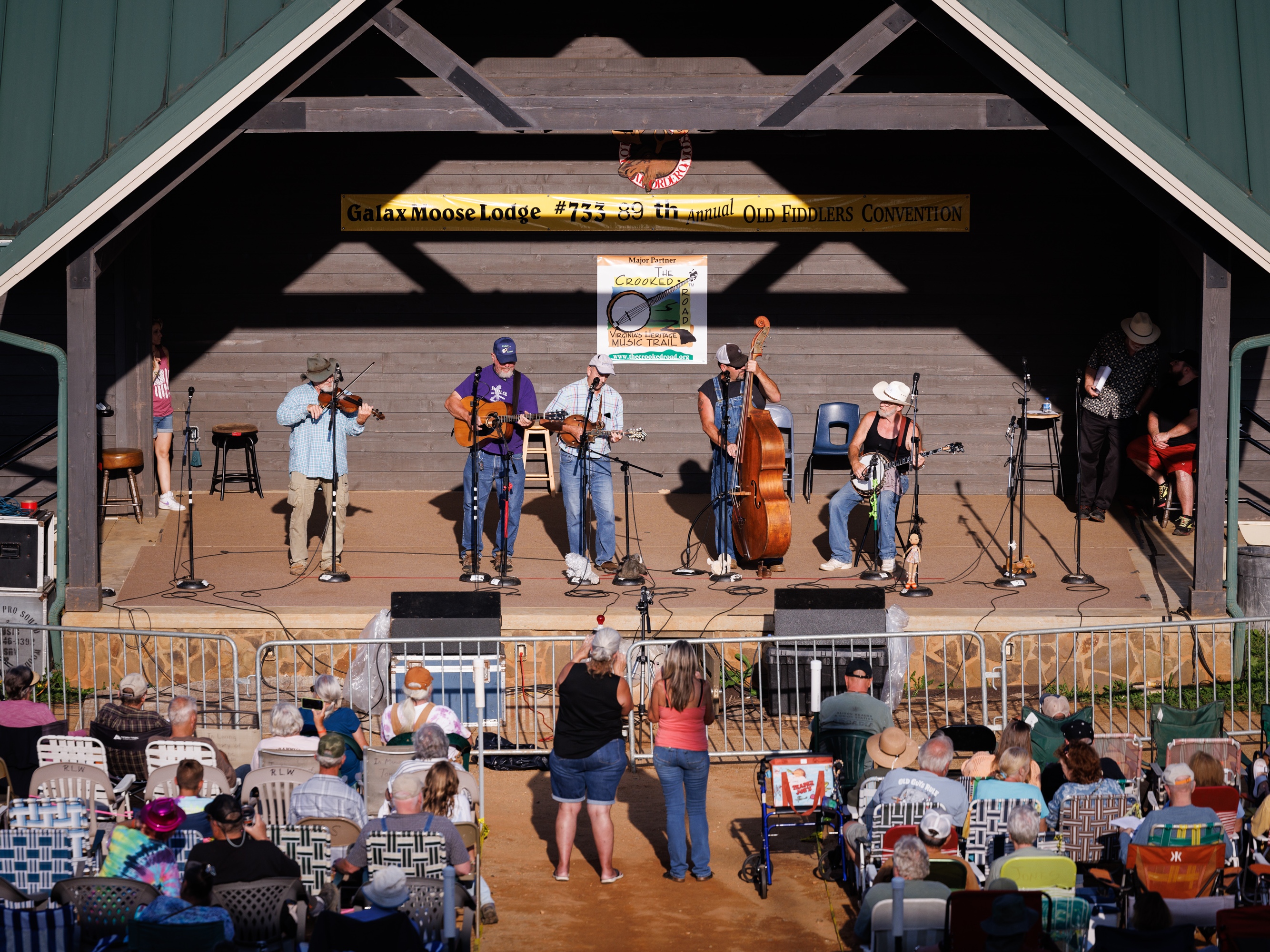 caption: A band competes against more than 100 others in the bluegrass band competition during the 89th Annual Old Fiddler's Convention on Saturday, Aug. 9, 2025, at Felts Park in Galax, Va.