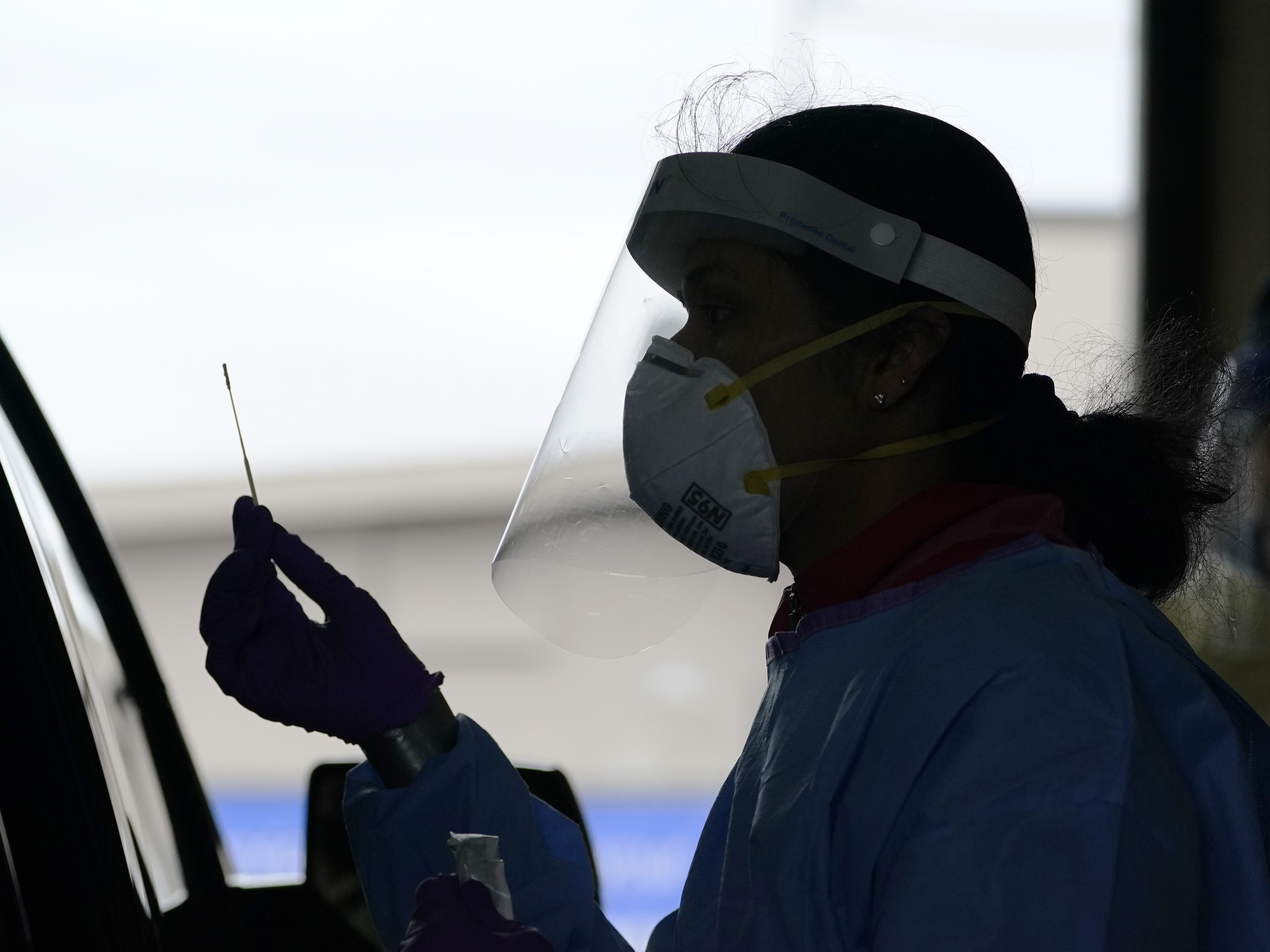 caption: A University of Washington research coordinator holds up a swab after testing a someone for coronavirus on Oct. 23 in Seattle. The U.S. recorded a record high number of new daily cases Friday.