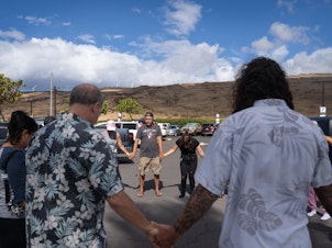 caption: A group of volunteers with Maui Medic Healers Hui gather before heading out to help people affected by the fires in Lahaina.