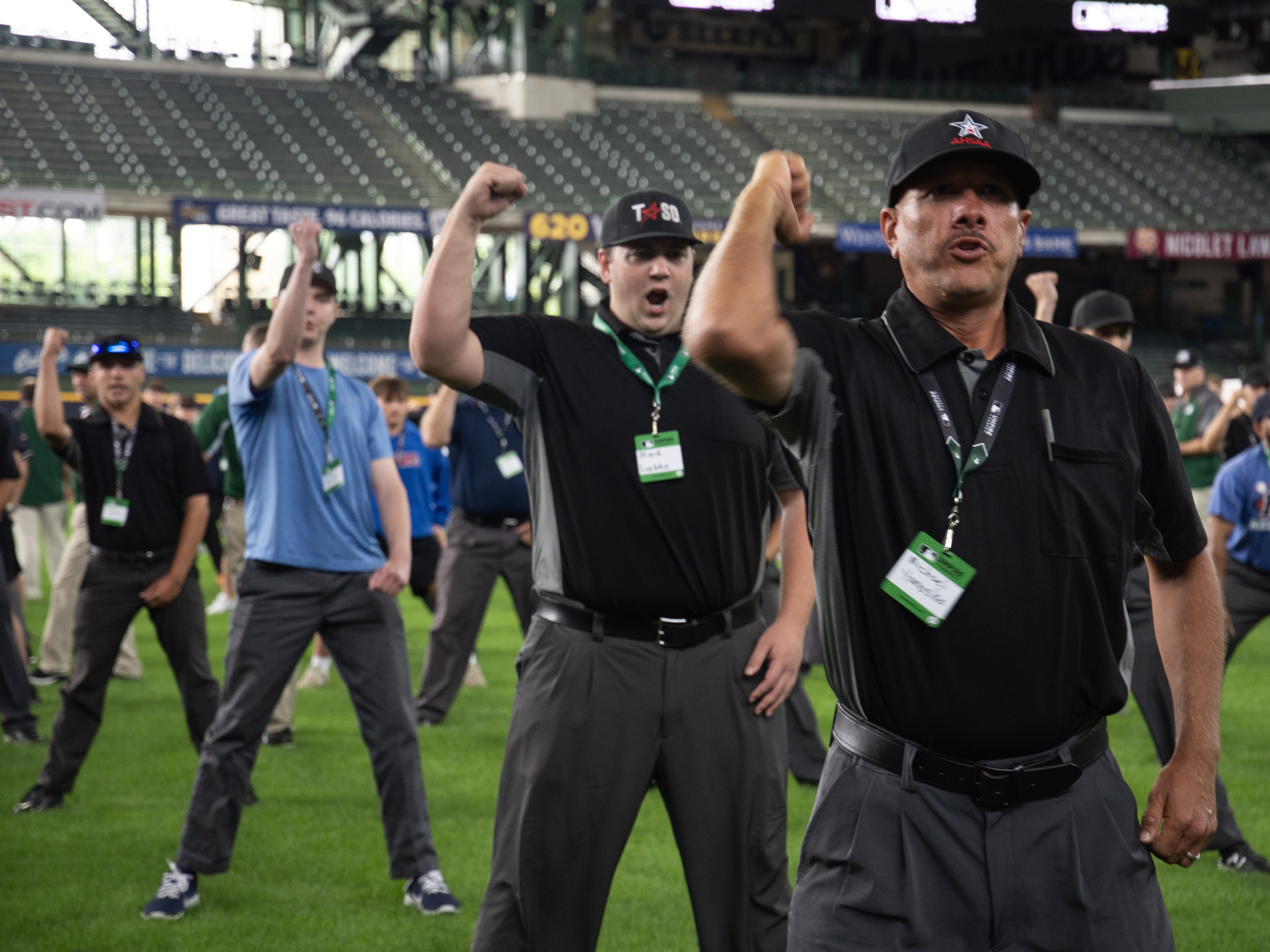 caption: Attendees at the July MLB Umpire Camp in Milwaukee began their day practicing the proper technique for an umpire's most common calls: strike, ball, safe and out.
