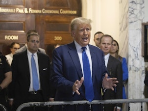 caption: Former President Donald Trump speaks to the media as he exits the courtroom of his civil business fraud trial at New York Supreme Court on Wednesday.