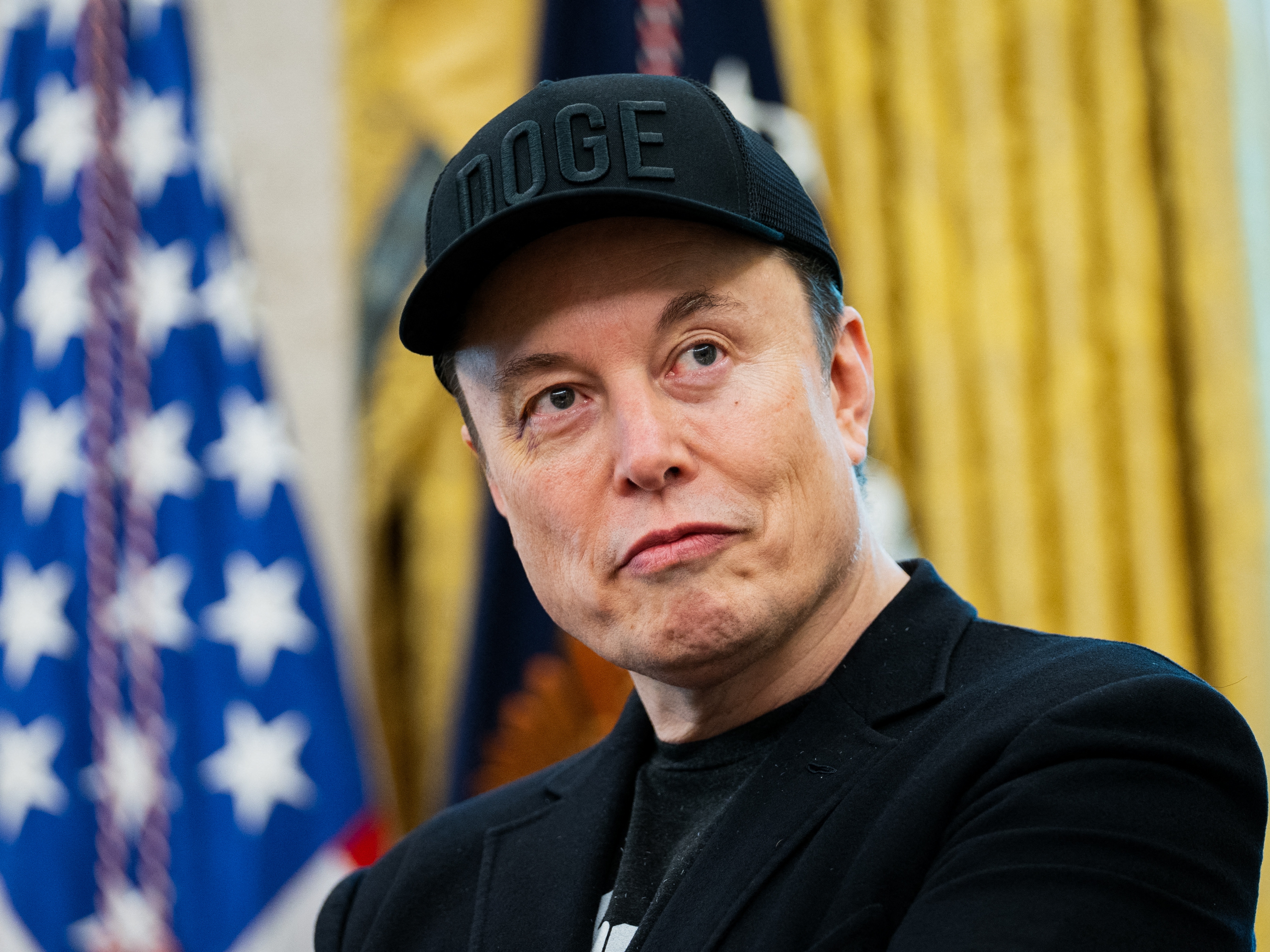 caption: Elon Musk looks on during a news conference with President Trump in the Oval Office on May 30.