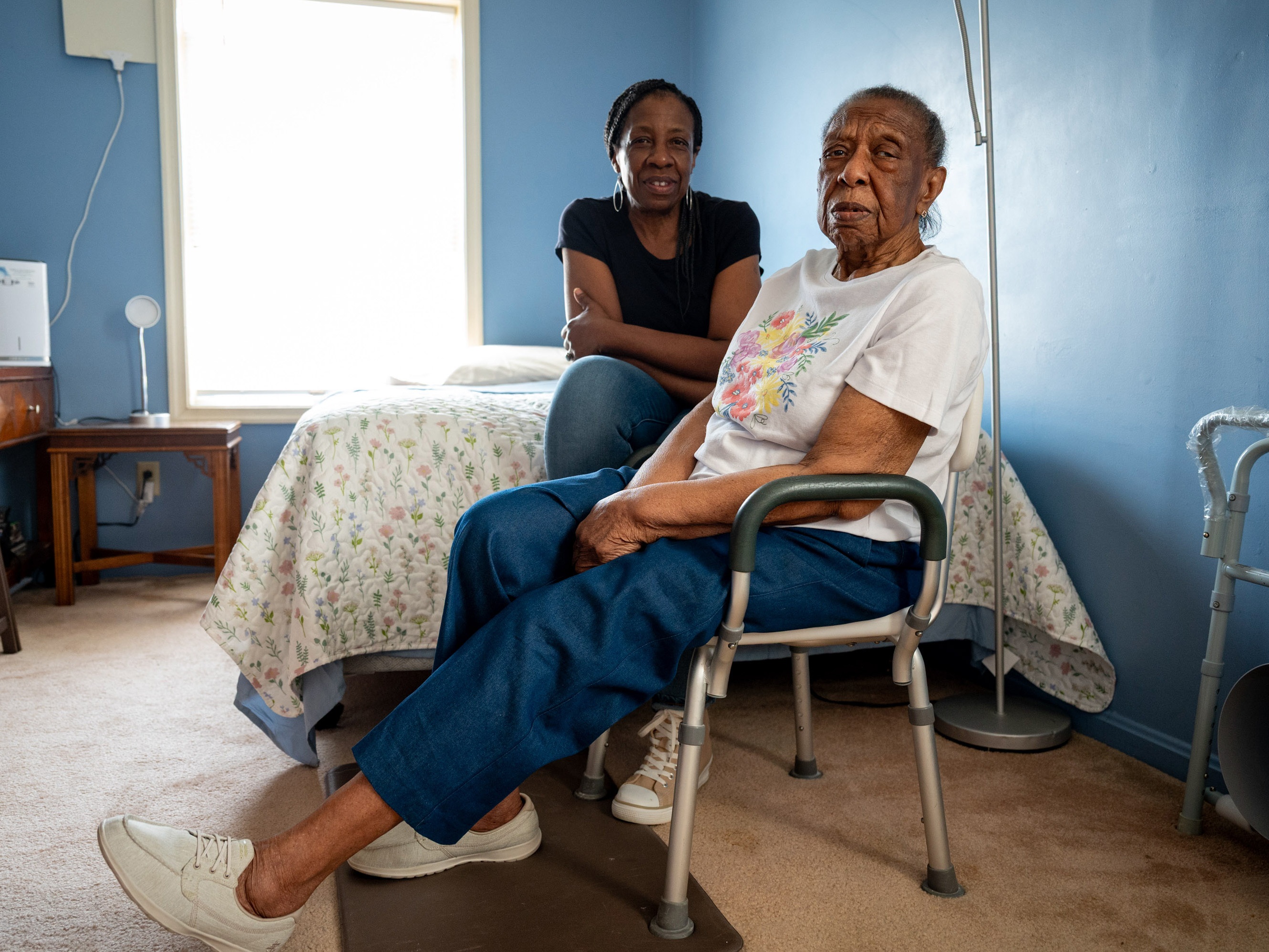 caption: Cookie Jones (left) sits with her mother, Valerie (right), in Cookie's home on June 4, 2025, in Bridgeport, Conn. Cookie Jones quit her job to care for her mother, who has Alzheimer's disease. She is one of thousands of unpaid family caregivers in Connecticut navigating financial and access barriers to treatment.