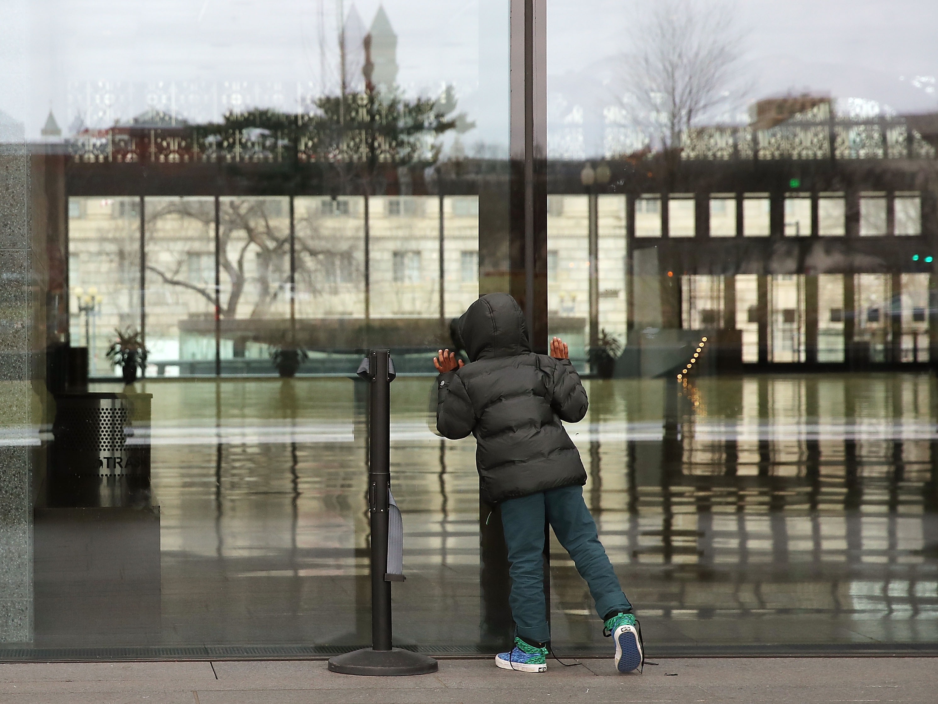 caption: A young visitor peers inside the National Museum of African American History that closed due to the partial shutdown of the U.S. government in January 2019 in Washington, D.C.