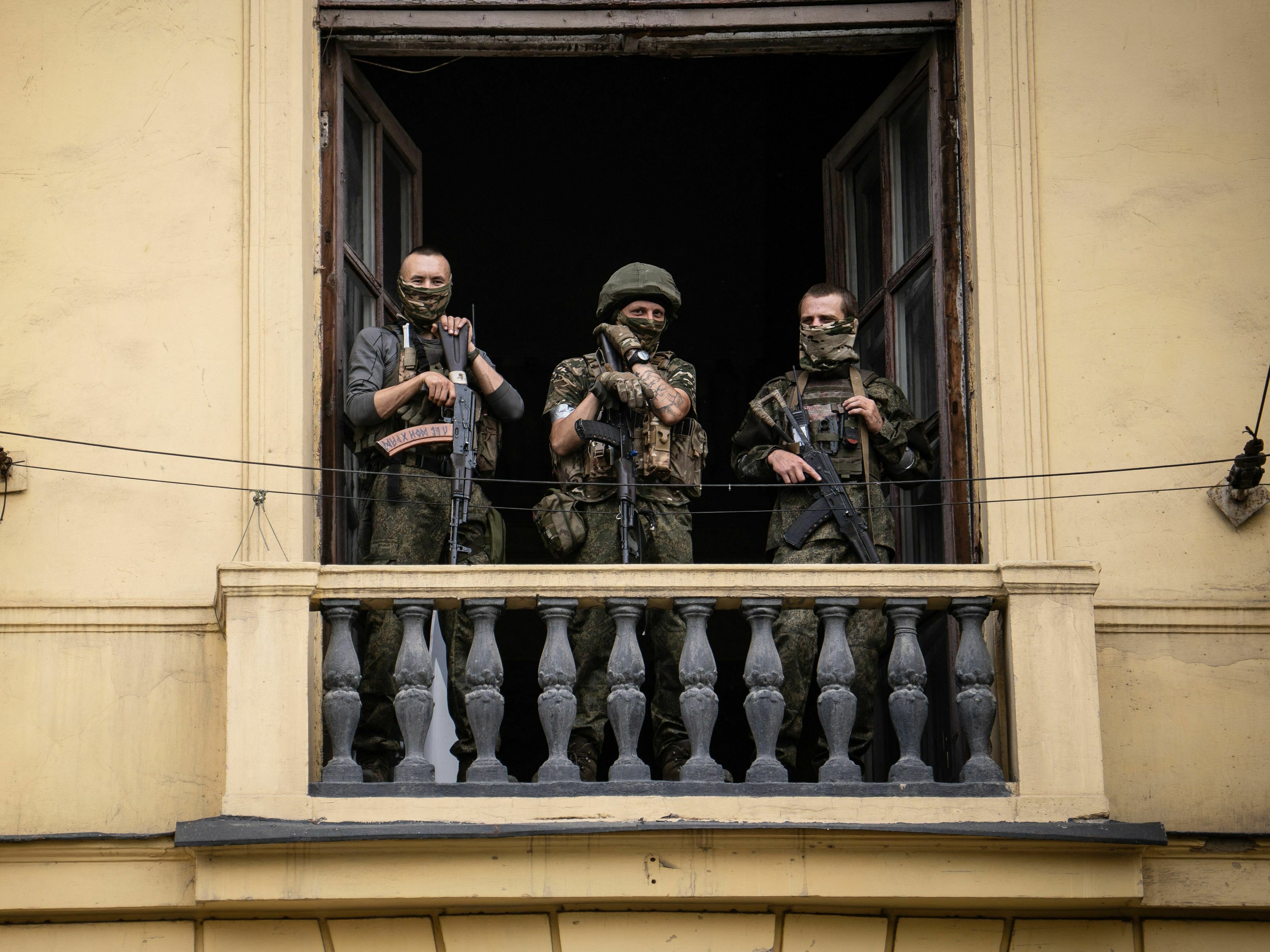 caption: Members of Wagner Group stand on the balcony of a building in the city of Rostov-on-Don on Saturday.
