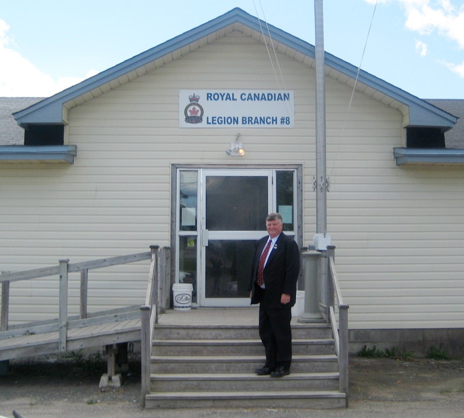caption: Gander, Newfoundland, Canada Mayor Claude Elliott stands in front of the Royal Canadian Legion Hall, which was used as a shelter for passengers of a flight stranded on Sept. 11, 2001. 