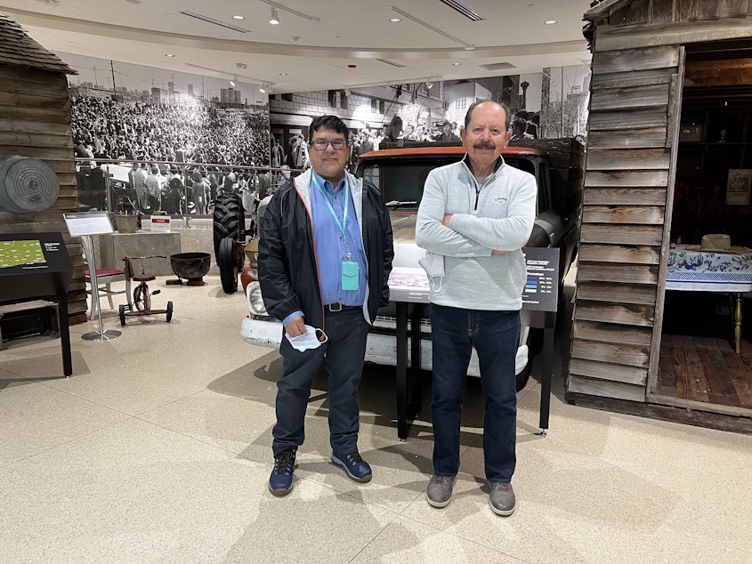 caption: Dr. Jerry Garcia (left) and Dr. Erasmo Gamboa (right) at Sea Mar Museum of Chicano/a and Latino/a culture, in South Park. Behind them are cabins from Sunnyside, WA, which were previously housing for agricultural workers.
