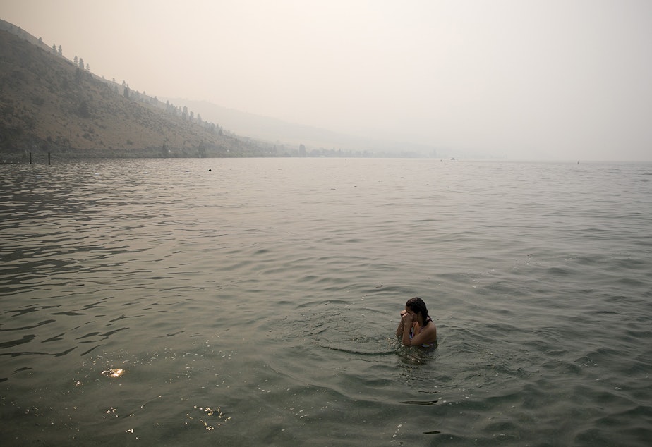 Bellaniy Baltazar, 13, rubs her eyes while swimming amidst heavy smoke from wildfires on Wednesday, August 15, 2018, at Lakeside Park in Chelan.