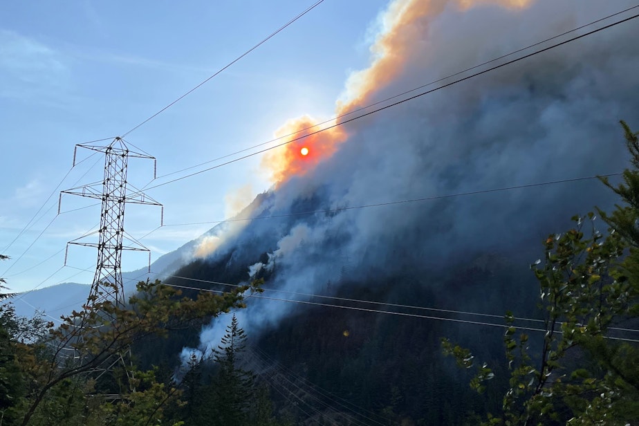 caption: The Sourdough Fire burns near Seattle City Light transmission lines in Washington's North Cascades on Aug. 12, 2023.