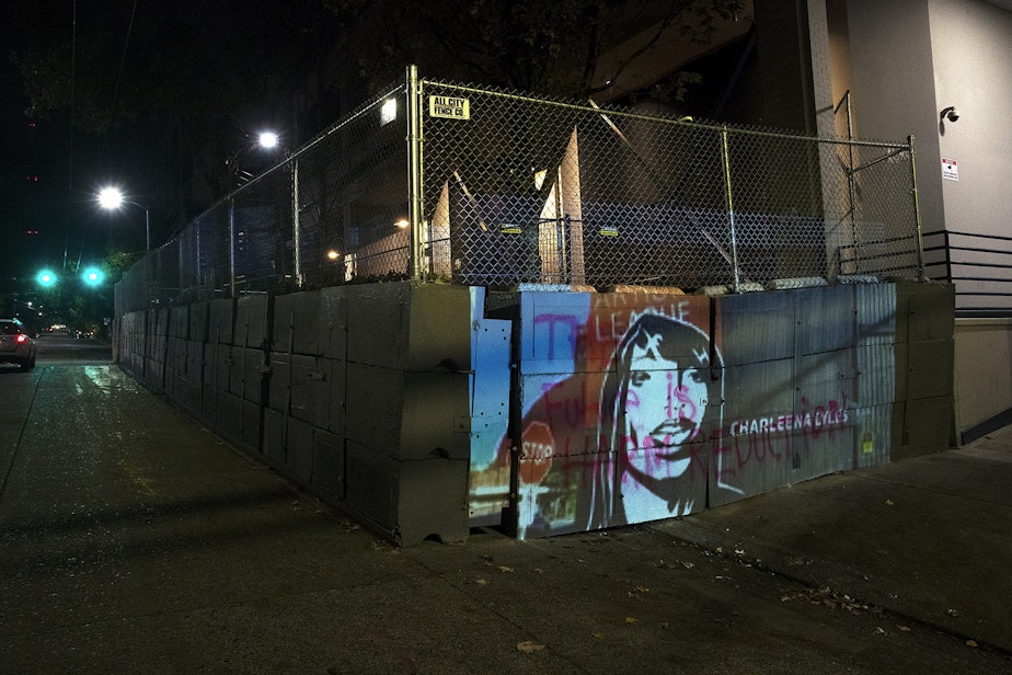 caption: An image of Charleena Lyles is projected onto the barricade surrounding the Seattle Police Department's East Precinct building on Monday, October 26, 2020, during the 150th day of protests for racial justice in Seattle. Lyles, a pregnant mother of four, was killed by Seattle Police Officers in 2017. 