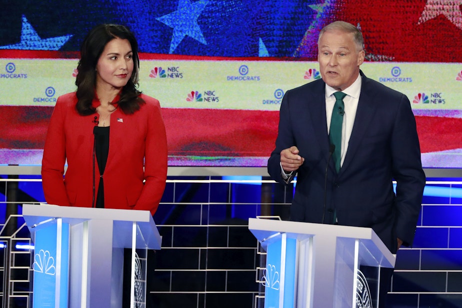 caption: Democratic presidential candidates Washington Gov. Jay Inslee, right, speaks during a Democratic primary debate hosted by NBC News at the Adrienne Arsht Center for the Performing Art, Wednesday, June 26, 2019, in Miami, as Rep. Tulsi Gabbard, D-Hawaii, listens. 