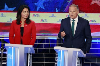 caption: Democratic presidential candidates Washington Gov. Jay Inslee, right, speaks during a Democratic primary debate hosted by NBC News at the Adrienne Arsht Center for the Performing Art, Wednesday, June 26, 2019, in Miami, as Rep. Tulsi Gabbard, D-Hawaii, listens. 