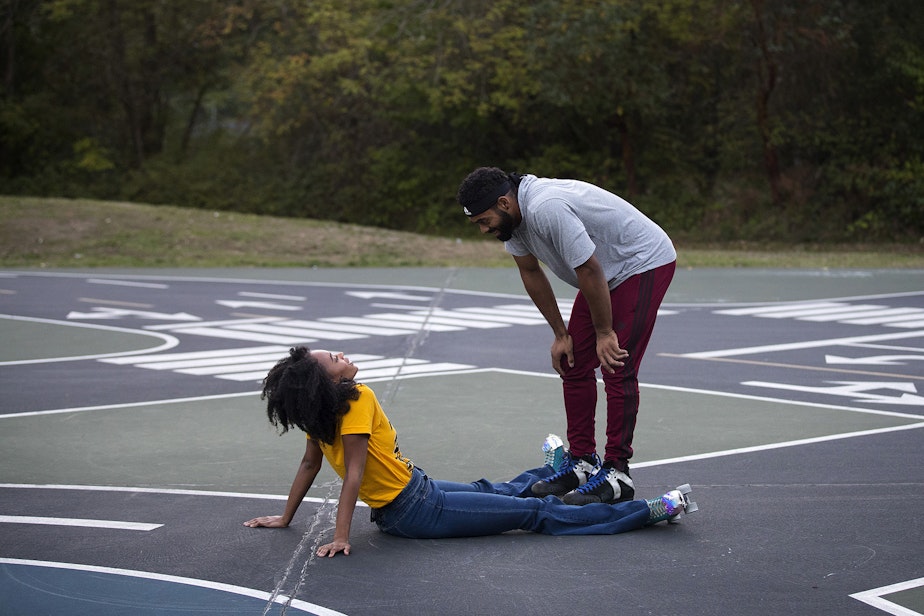 caption: JNiyah Williams, left, and Kayan Hanks, right, take a moment after JNiyah fell while skating together on Tuesday, October 6, 2020, at the Bicycle Playground in White Center.