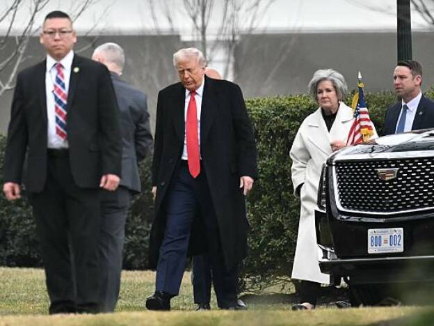 caption: US President Donald Trump, accompanied by Chief of Staff Susie Wiles, arrives at the White House.