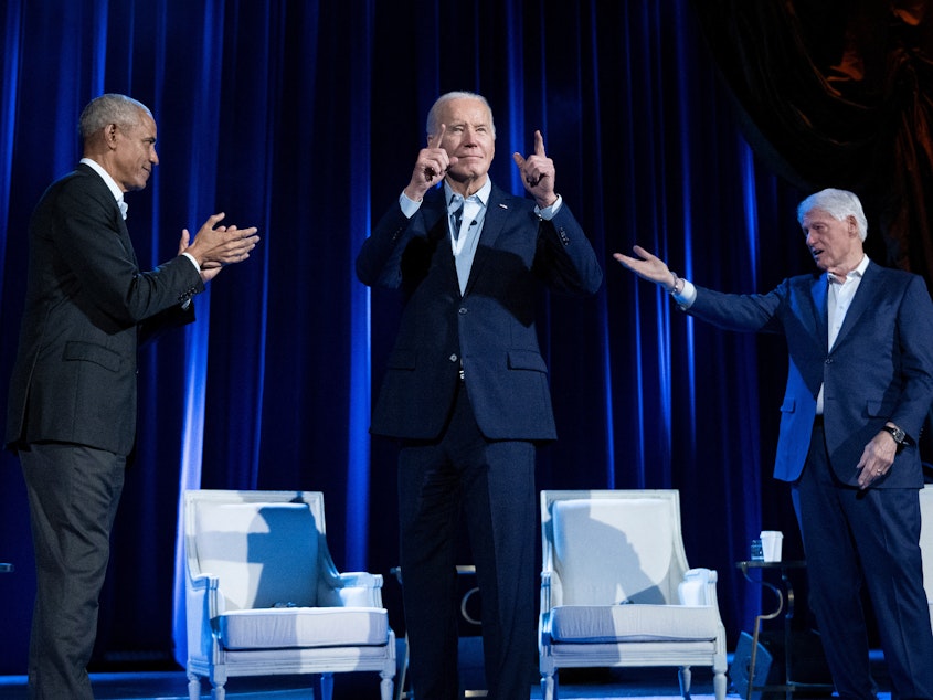 caption: Former President Barack Obama (left) and former President Bill Clinton (right) cheer for President Biden during a campaign fundraising event at Radio City Music Hall in New York City on March 28.
