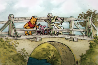 caption: A screenshot of Winnie-the-Pooh tossing sticks into the river below.
