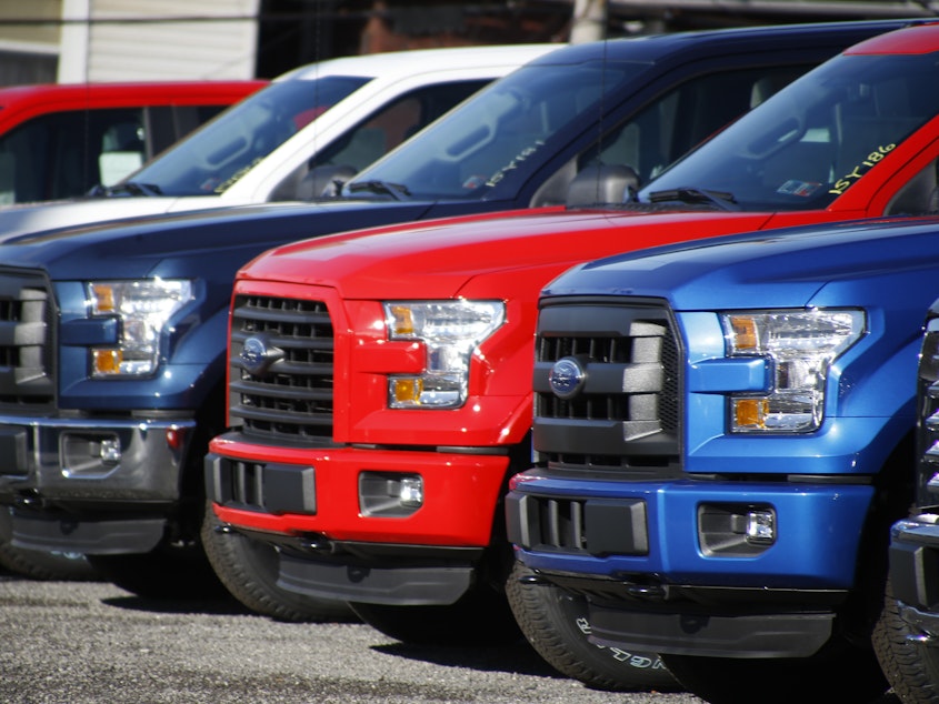 caption: A row of 2015 Ford F-150 pickup trucks parked at a sales lot in Butler, Pa.
