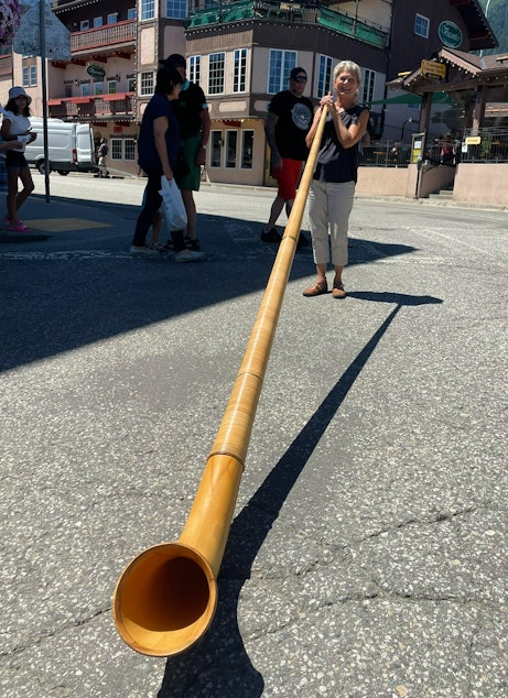 caption: Janet Malo plays her alphorn in downtown Leavenworth, Washington. 
