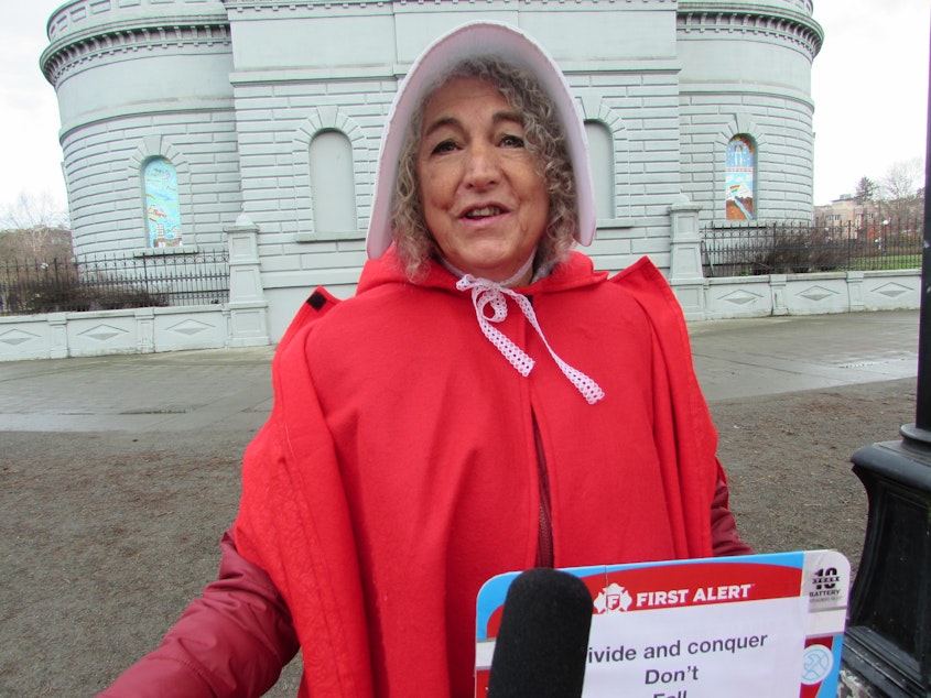 caption: Hallette Salazar dressed in 'Handmaid's Tale' cloak and bonnet before the Seattle women's march Saturday.