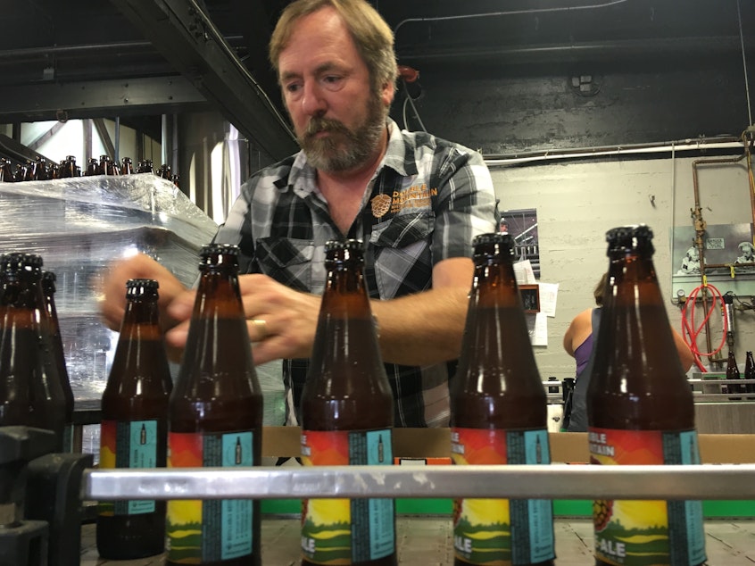 caption: Double Mountain Brewery founder Matt Swihart grabs freshly bottled pale ale from the bottling line in Hood River. The ale is among the first to be sold in Oregon's new refillable beer bottles.