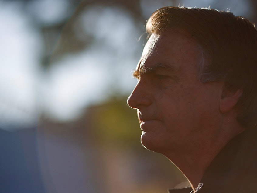 caption: Brazil's former President Jair Bolsonaro at Brasilia International Airport on Thursday.