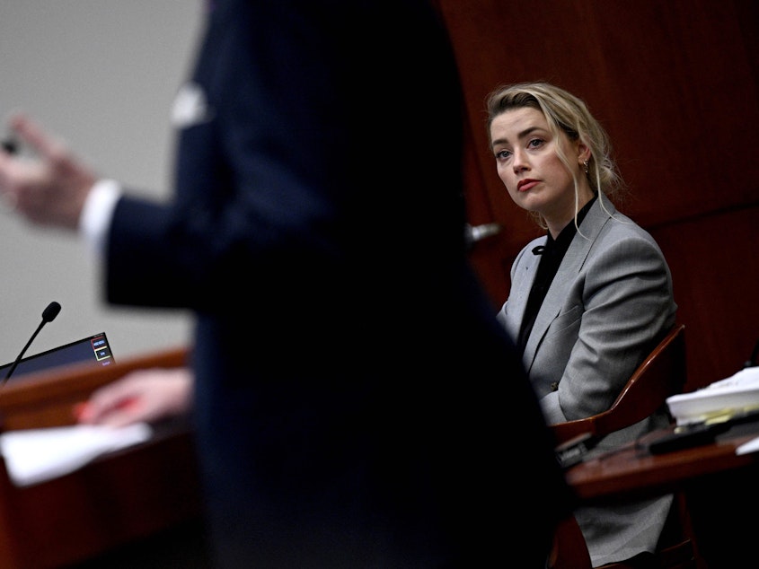 caption: Amber Heard listens during the trial of a $50 million defamation lawsuit against her by ex-husband Johnny Depp in Fairfax, Va.