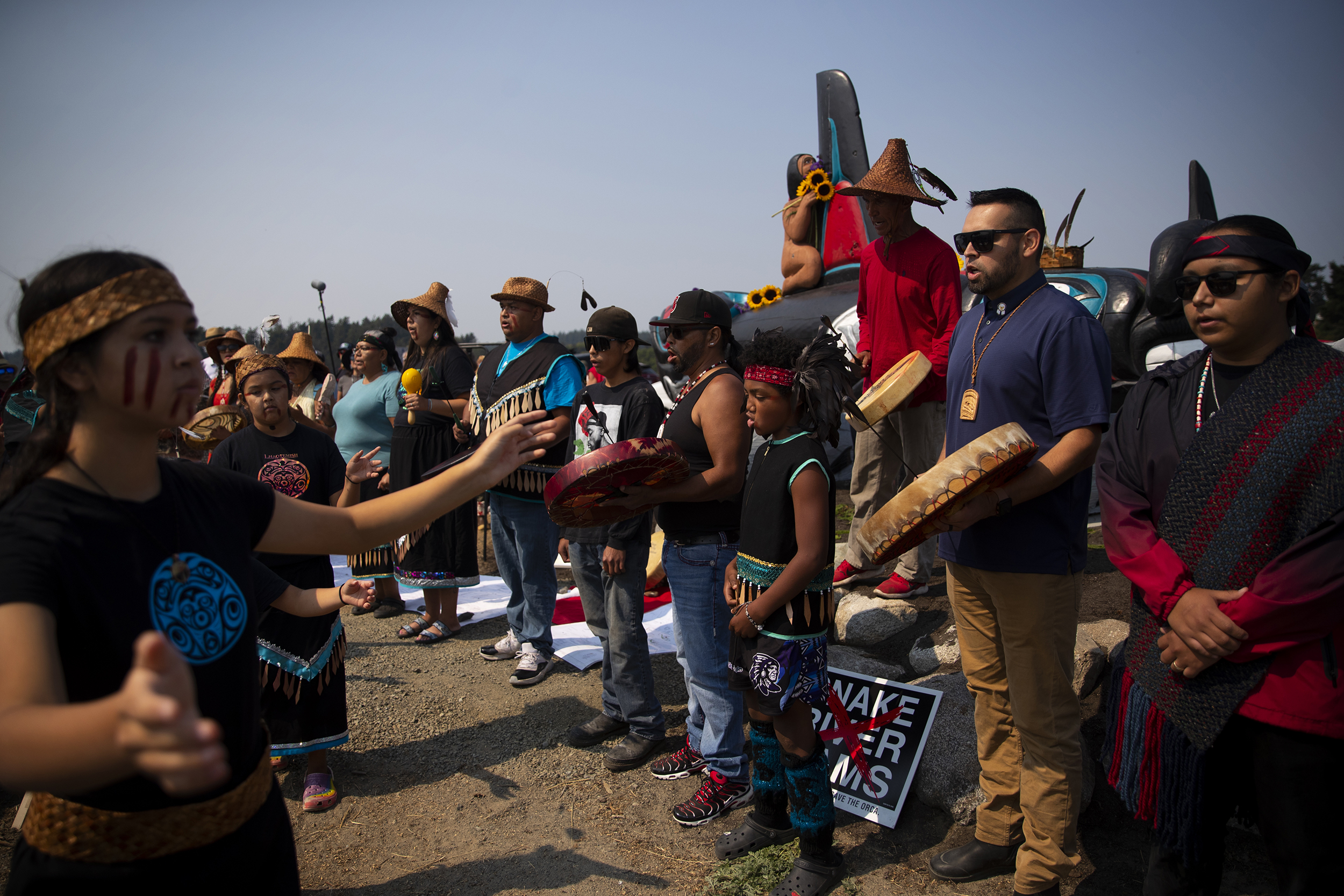 caption: Lummi tribal members including Chairman Anthony Hillaire, second from right, begin a celebration of life for Tokitae on Sunday, August 27, 2023, at Jackson Beach on San Juan Island. 