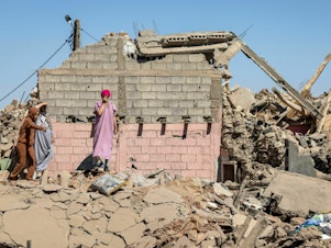 caption: Villagers inspect the rubble of collapsed houses in Tafeghaghte, southwest of Marrakesh, on Sept. 10.