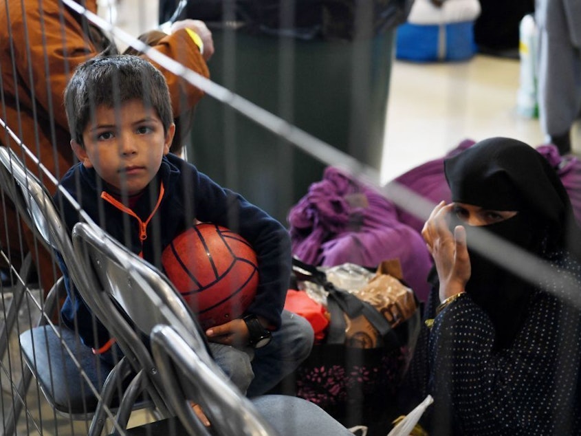 caption: Afghan refugees wait to be processed Sept. 8 inside Hangar 5 at Ramstein Air Base in Germany.