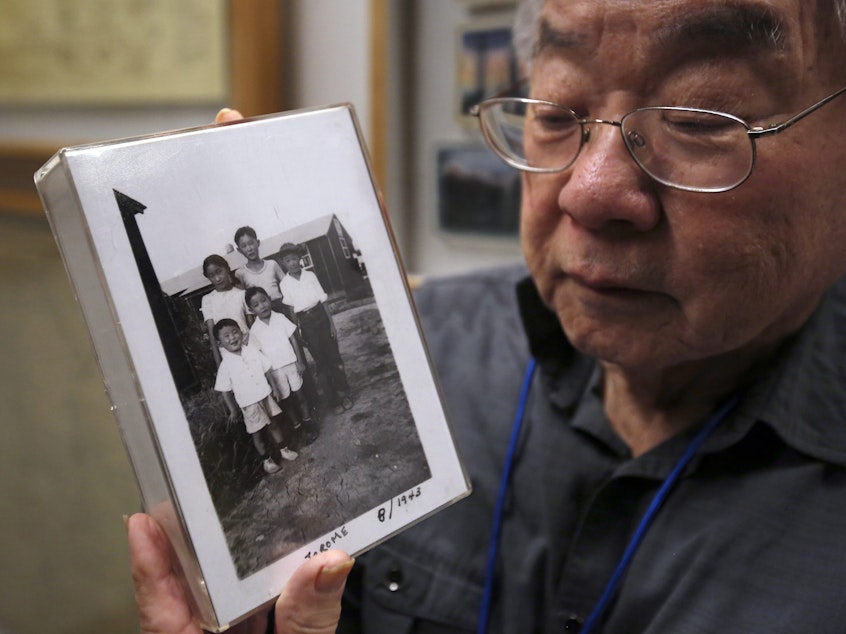 caption: During a visit last week to the California Museum in Sacramento, Les Ouchida holds a 1943 photo of himself (front row center) and his siblings taken at the internment camp in Jerome, Ark., that his family was moved to from their home near Sacramento in 1942.