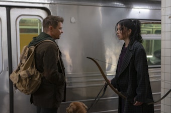 caption: (L-R): Hawkeye/Clint Barton (Jeremy Renner) and Kate Bishop (Hailee Steinfeld) aim to please in Marvel's <em>Hawkeye</em>.