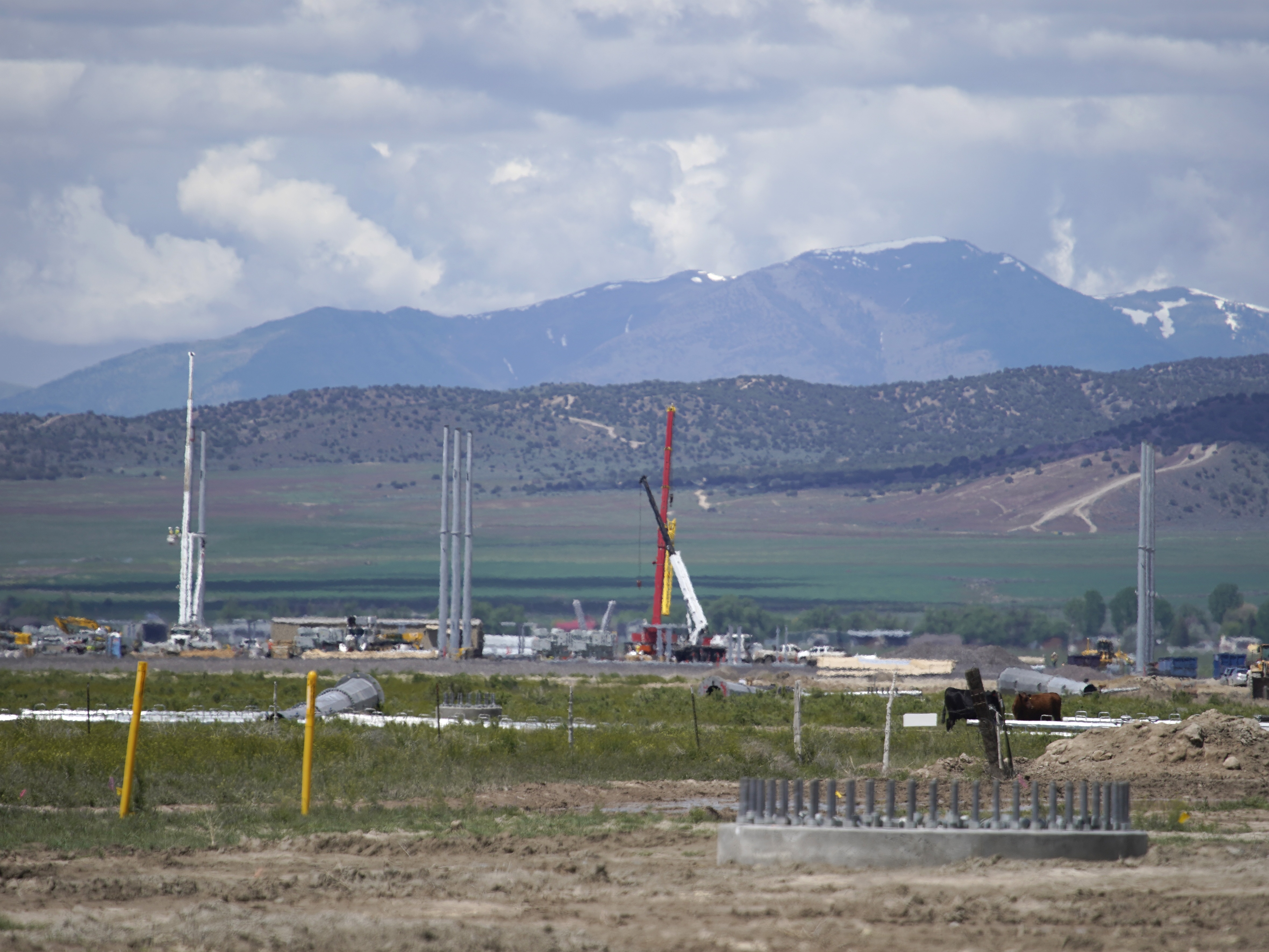 caption: Workers build an electrical substation for a new Facebook data center under construction on May 29, 2019 in Eagle Mountain, Utah.