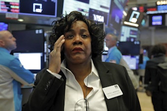 caption: Yvette Arrington with the New York Stock Exchange trading floor operations watches the market slide on March 9 as coronavirus fears grip the financial markets.