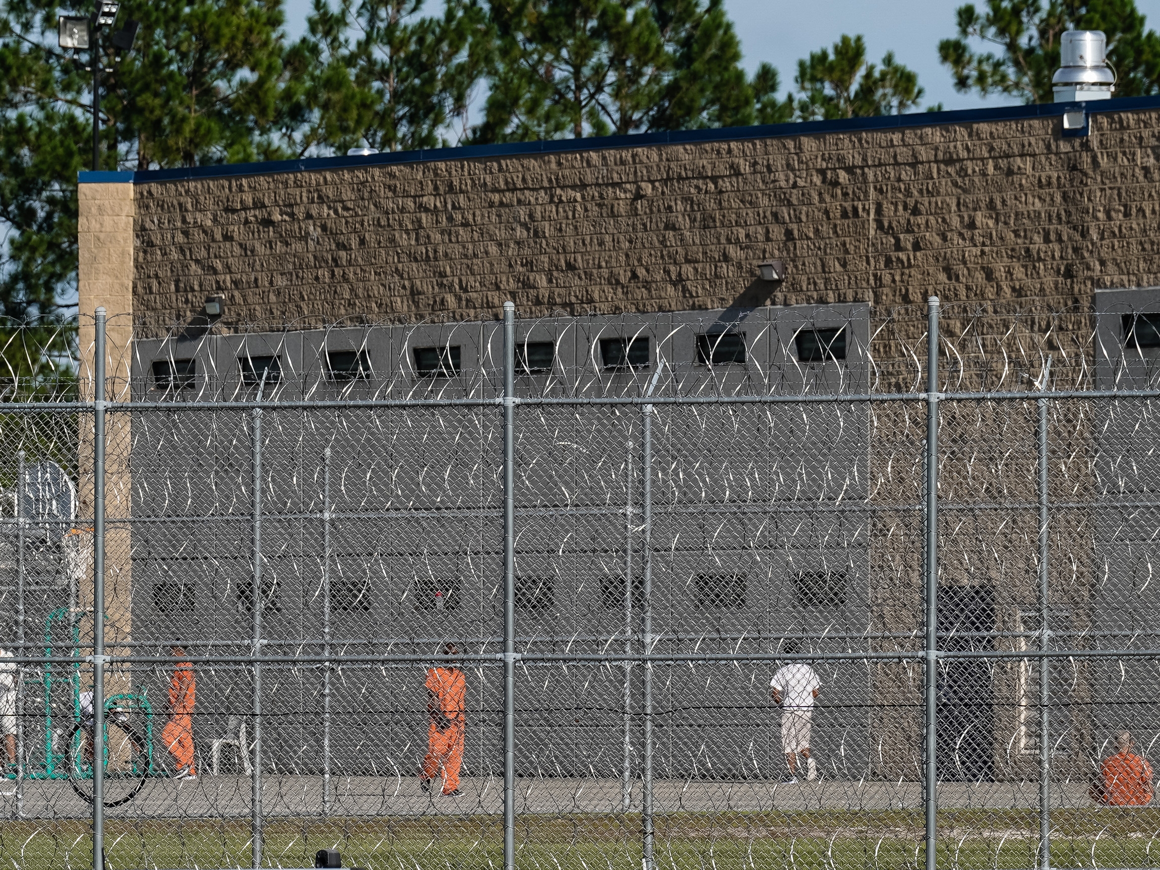 caption: Detainees are seen in a yard at the Folkston ICE Processing Center on Sept. 9, 2025, in Folkston, Georgia. The state's two Democratic senators are demanding answers from the Department of Homeland Security after more than a dozen people have died in immigration detention facilities.