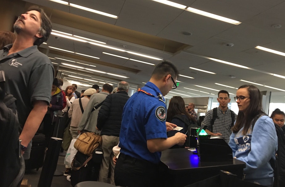 caption: Passengers in a security line at San Francisco International Airport.